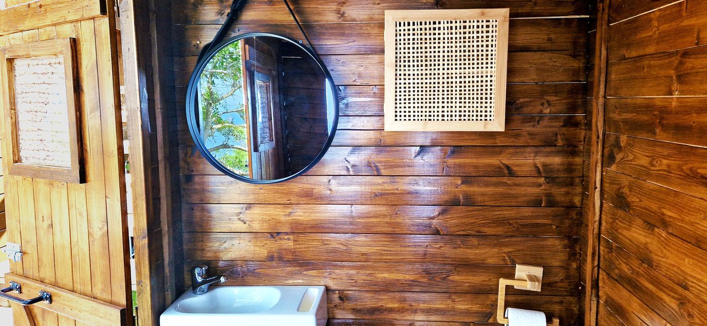 Salle de bain avec miroir du lodge La Cahute