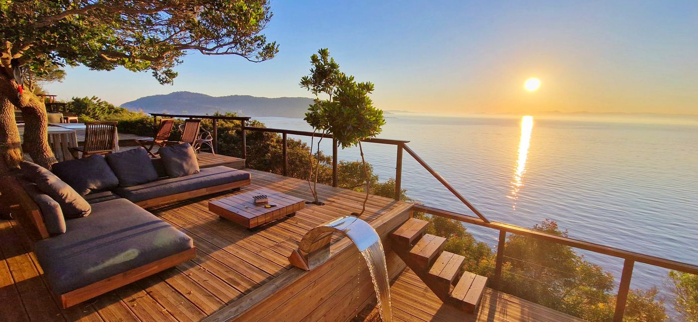 Salon de plein air de Soléa Lodges au coucher du soleil, vue mer