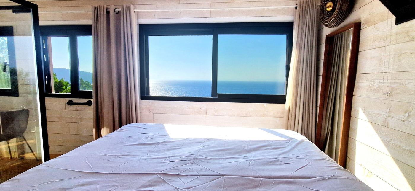 Chambre du lodge L'Hippocampe, grande baie vitrée vue mer